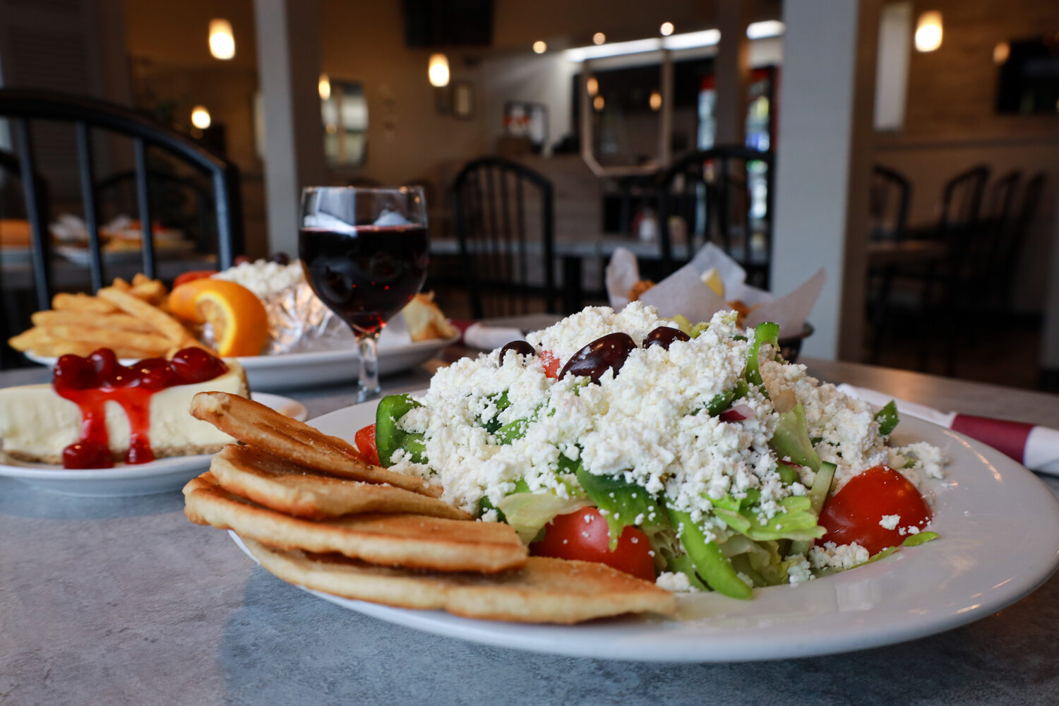 Greek salad, pita and dishes pictured on Over the Coals’ existing website